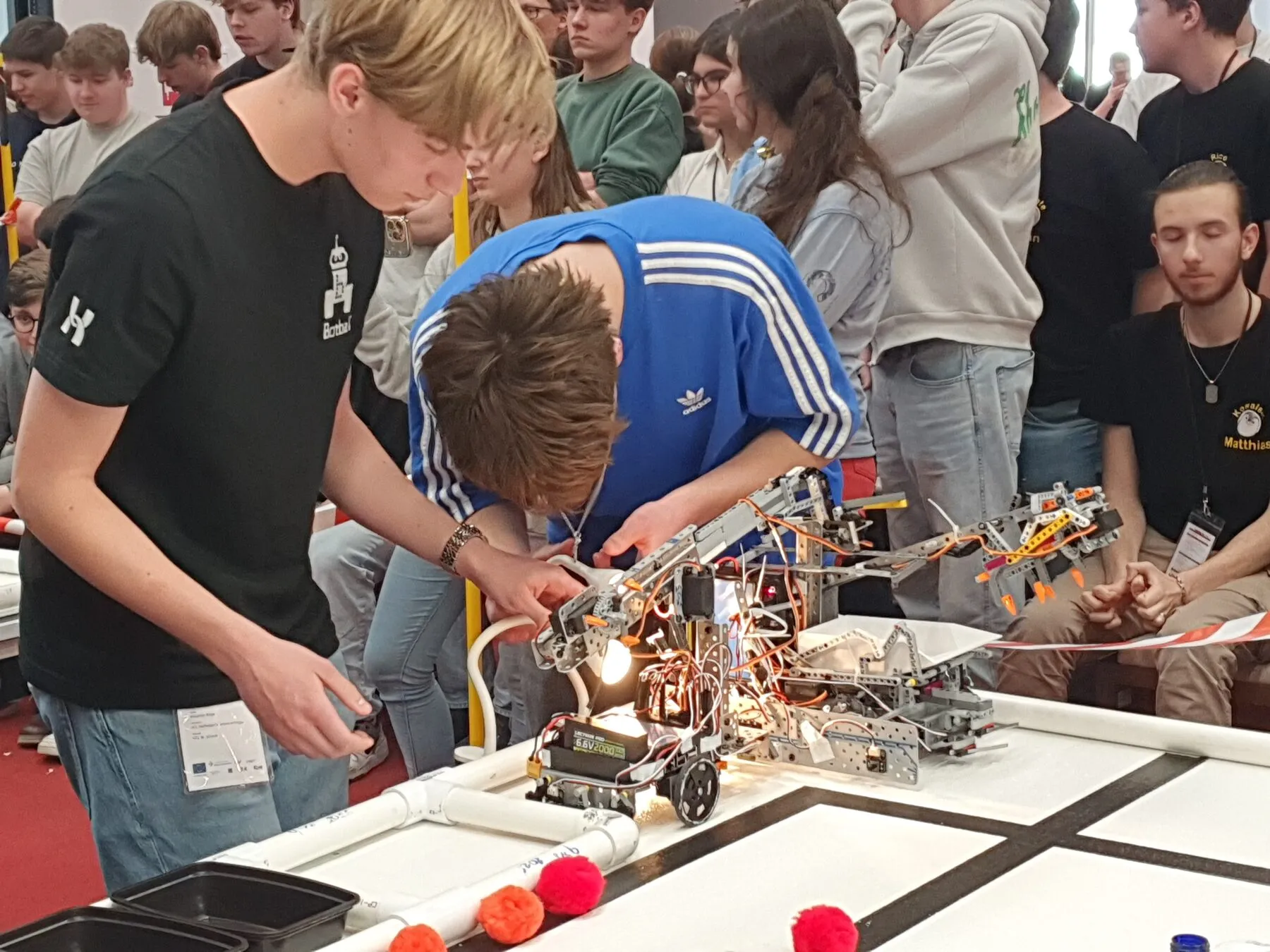 Schüler:innen arbeiten während des Wettbewerbs an ihrem Roboter